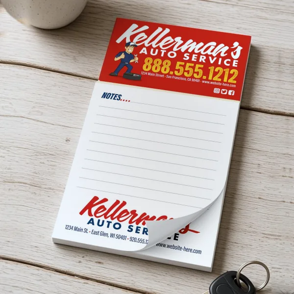 Kellerman's Auto Service magnetic notepad with a mechanic mascot and lined pad, beside a coffee mug and car keys.