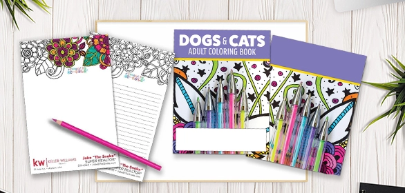 Floral coloring notepads and a Dogs and Cats adult coloring book with colored gel pens on white wood.