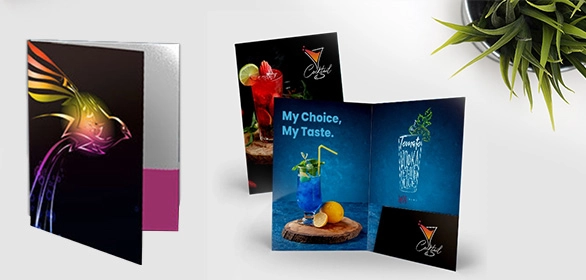 Black presentation folder with colorful bird design beside an open folder showing cocktail drink photos.