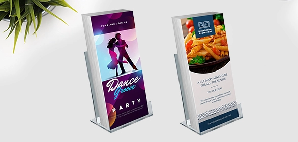 Two acrylic table tent displays showing a purple dance party flyer and a restaurant menu with fried food photo.