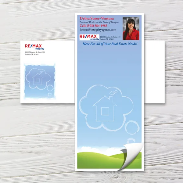 Custom notepad with blue sky design, house illustration, and green landscape footer on white paper.