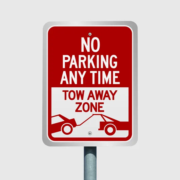 Red and white aluminum no parking tow away zone sign on gray pole