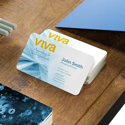 Heavy stock UV coated business cards with blue and white design on wooden desk