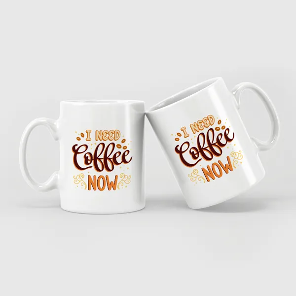 White ceramic coffee mugs with brown and orange "I Need Coffee Now" text design, promotional drinkware set of 2