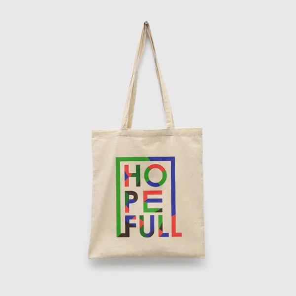 Beige canvas tote bag with colorful geometric text design and dual handles, promotional product