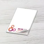 Custom 3 x 4 inch small memo pad with a watch repair gear logo on white wood