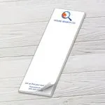 Custom 3 x 9 inch long notepad with a House Search Co. logo, top sheet curling, on white wood