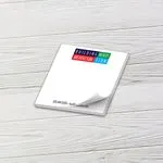 Custom 4 x 4 inch square notepad with a colorful block letter logo, top sheet curling, on white wood