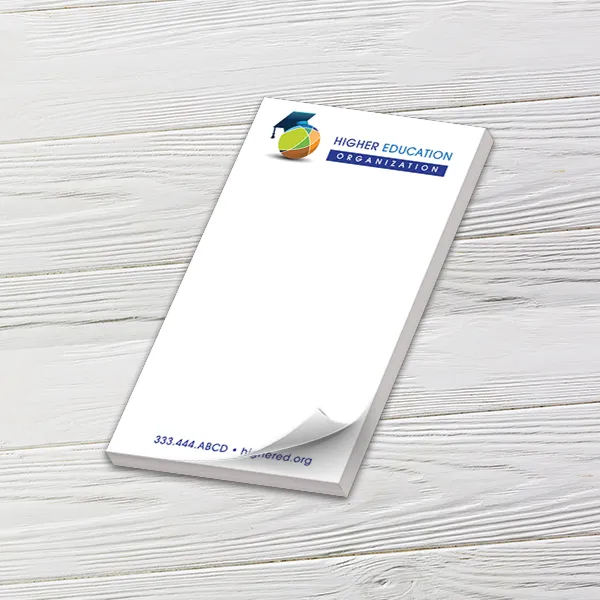 Custom 4 x 7 inch memo pad with a graduation cap logo, top sheet curling, on white wood