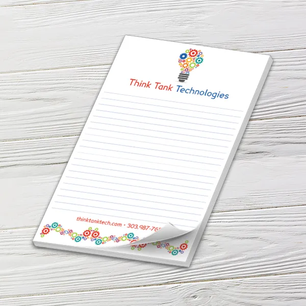 Custom 5.5 x 8.5 inch Think Tank Technologies lined notepad with a curled sheet on whitewashed wood