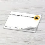 Custom 5 x 3 inch landscape tear-off pad with an investigations eye logo on white wood
