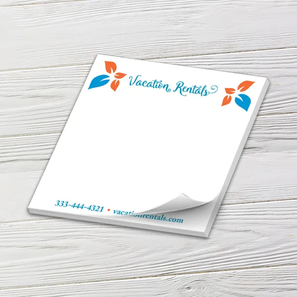 Custom 5 x 5 inch square memo pad with a vacation rental logo and phone number on white wood