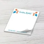 Custom 5 x 5 inch square memo pad with a vacation rental logo and phone number on white wood