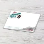 Custom 6 x 4 inch horizontal notepad with a Premium Tires logo, top sheet curling, on white wood