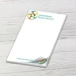 Custom 6 x 9 inch Connections Drivers Ed notepad with a curled top sheet on white wood boards