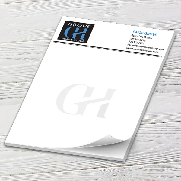 Custom 8.5 x 10.5 inch full-page notepad with a Grove Homes Group header and GH watermark, on white wood