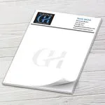 Custom 8.5 x 10.5 inch full-page notepad with a Grove Homes Group header and GH watermark, on white wood
