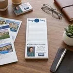 Custom 3.5 x 8 inch realtor to-do notepad on a desk with listing flyers and a business card