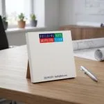 Custom 4 x 4 inch square notepad with a block letter architecture logo standing on a desk by a window
