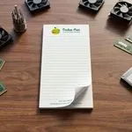 Custom 4 x 8 inch lined notepad for a computer repair shop, top sheet curling, on a desk with fans and RAM