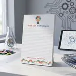 Custom 5.5 x 8.5 inch Think Tank Technologies lined notepad standing on a desk with a tablet