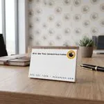 Custom 5 x 3 inch landscape notepad for an investigations firm standing on an office desk with a pen