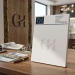 Custom 8.5 x 10.5 inch Grove Homes Group full-page notepad standing in an office by a monogram wall sign