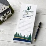 Custom 3 x 9 inch insurance agency long notepad with pine crest, phone and Policy Notes lines, beside a model house