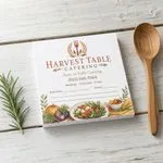 Custom 6 x 6 inch catering company notepad with event date and guest count lines, beside a wooden spoon